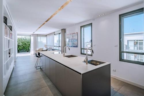 a kitchen with two sinks and large windows at Shenkin Dream - 4 BR in Tel Aviv