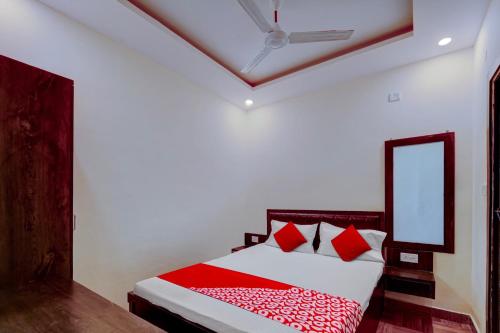 - une chambre avec un lit doté d'oreillers rouges et d'un miroir dans l'établissement Hotel Days Inn, à Rānchī