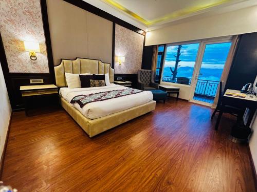 a hotel room with a bed and a large window at Grand View Hotel in Dalhousie