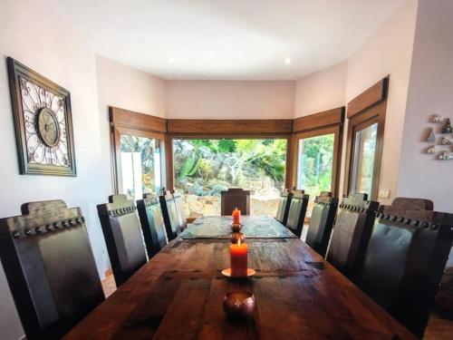a dining room with a long wooden table and chairs at Villa Alta Vista in Zahara de los Atunes