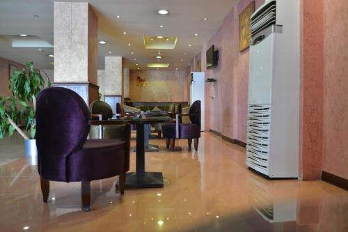 een lobby met een tafel en stoelen in een kamer bij العلمين للشقق المخدومة in Al Jubail