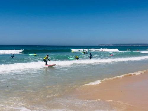 a group of people riding the waves in the ocean at Villa Alta Vista in Zahara de los Atunes