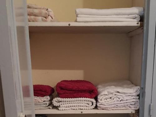 un armario con toallas rojas y blancas en un estante en Marrakech, en Marrakech