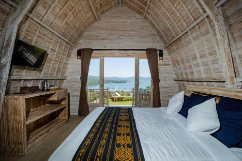 a bedroom with a bed and a large window at Samuh Camp Kintamani in Kintamani