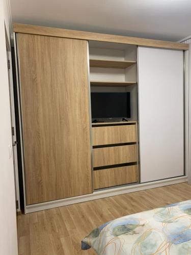 a bedroom with a tv and a sliding glass door at Apartament central in Râmnicu Vâlcea