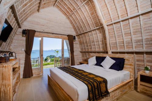 um quarto com uma cama grande e uma janela grande em Samuh Camp Kintamani em Kintamani