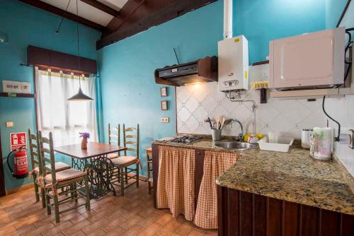 a kitchen with a counter and a table with chairs at Apartamentos El Cueto in Oviñana