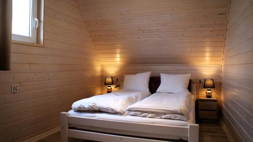 sypialnia z 2 łóżkami w drewnianej ścianie w obiekcie Sun Club - Modern Houses Mielno - Mielenko w mieście Mielno