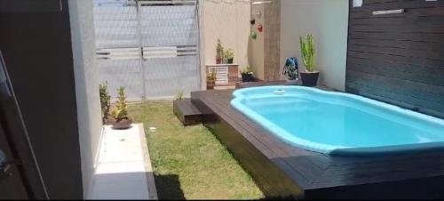a bathroom with a large blue tub in the grass at Casa com Piscina perto da praia in Salvador