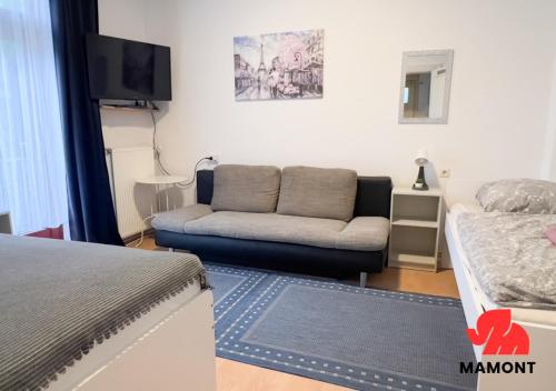 a living room with a couch and a tv at Ganze Monteurwohnung zum Entspannen in Bremen