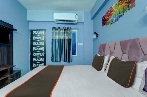 a bedroom with a large bed with blue walls at Collection O Hotel Dream Villa in Patna