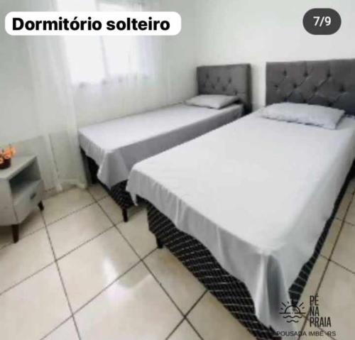 2 Betten nebeneinander in einem Zimmer in der Unterkunft Pousada Pé na Praia in Imbé