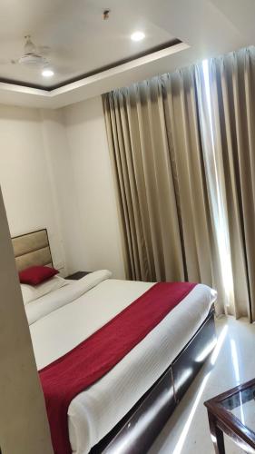 a bedroom with a bed and a window with curtains at Hotel Urban Blueberry in Zirakpur