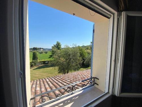 an open window with a view of a garden at Locanda LaRotonda in Villa Verucchio