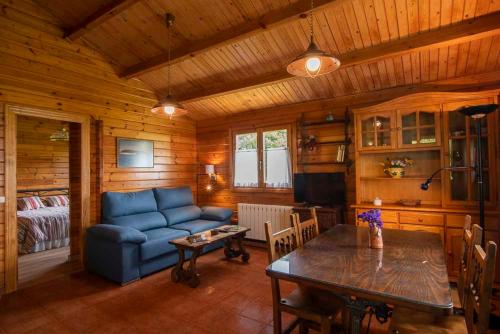 a living room with a blue couch and a table at Apartamentos El Cueto in Oviñana