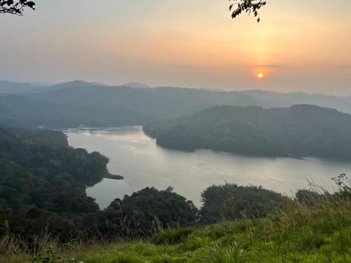 a view of a body of water at sunset at Munnar Village Homes in Munnar