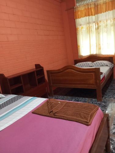 a room with two beds and a towel on them at Misahualli Laguna Paikawe B&B in Puerto Misahuallí