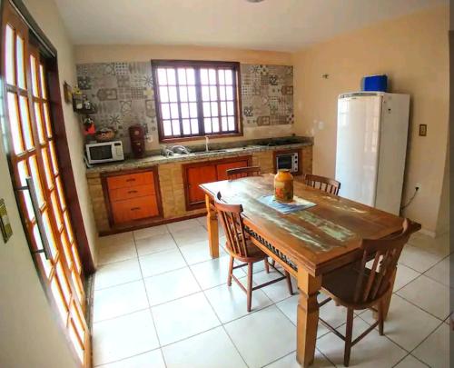 cocina con mesa de madera y nevera en Casa Colonial en São Lourenço