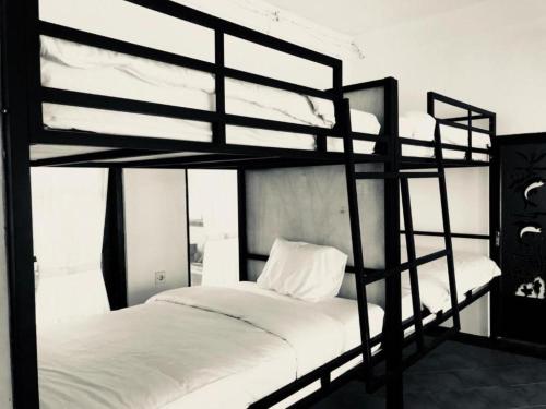 a black and white bedroom with two bunk beds at Bali Telaga Hati Yoga Healty And Retreat Center in Sanur