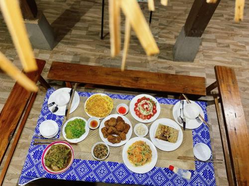 a table with plates of food on a blue and white table cloth at Homestay Chinh Bi in Yên Bái