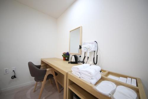 Habitación con escritorio con cámara y toallas. en HARU Hotel, en Changwon