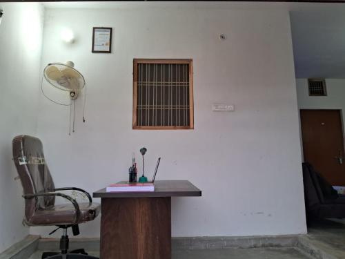 Habitación con escritorio, silla y ventana. en ARNAV GUEST HOUSE en Gorakhpur