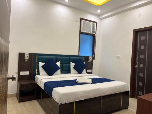 a bedroom with a large bed with blue pillows at ARNAV GUEST HOUSE in Gorakhpur