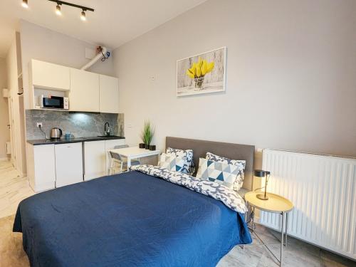 um quarto com uma cama azul e uma cozinha em MoonApart A2 em Varsóvia
