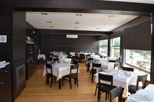 a dining room with white tables and black walls at Figurino do Douro in Melres