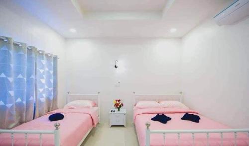 - 2 lits dans une chambre rose et bleue dans l'établissement ยิปซี รีสอร์ท, à Ban Khao Ya Nua