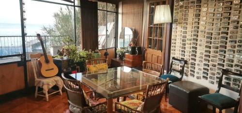 Habitación con mesa, sillas y guitarra en Casa Hostal Vista al Mar, en Valparaíso