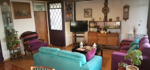 salon z niebieskimi kanapami i telewizorem w obiekcie Casa Hostal Vista al Mar w mieście Valparaíso