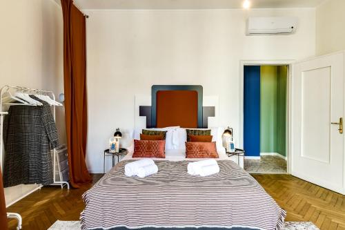 una camera da letto con un grande letto con cuscini arancioni di Sweet Inn - Ariberto a Milano