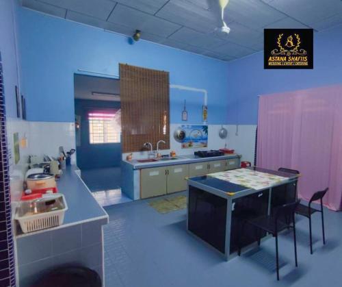 a kitchen with a sink and a table with chairs at ASTANA SHAFIIS in Malacca