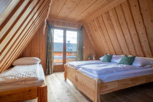 um quarto com 2 camas e uma grande janela em Miętowa Osada Czerwienne em Ciche