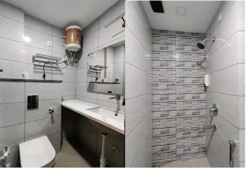 y baño con aseo, lavabo y ducha. en Boutique Hotel vivaan suites en Noida