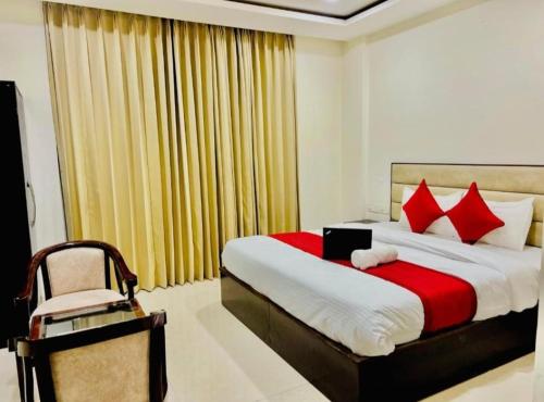 a bedroom with a large bed and a chair at Hotel Urban Blueberry in Zirakpur
