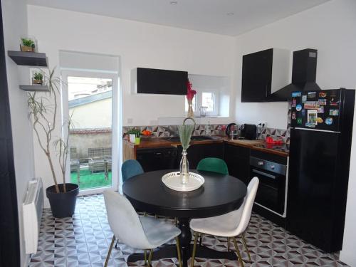 une cuisine avec une table et des chaises dans une cuisine dans l'établissement Appartement Artem neuf et terrasse, à Nancy