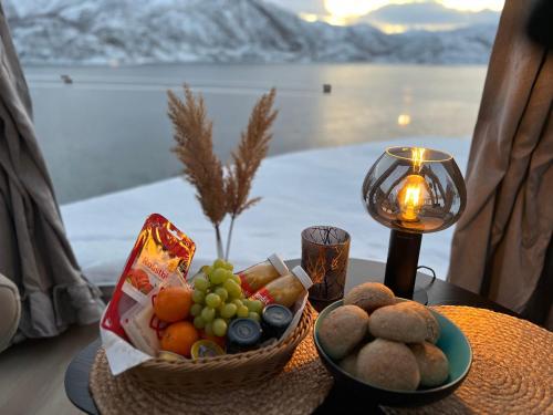 una mesa con una cesta de fruta y una vela en Lofoten glampingdome, en Myrland