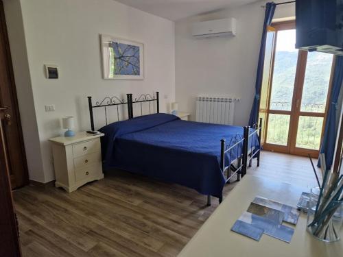1 dormitorio con 1 cama azul y suelo de madera en Agriturismo Nonno Ninuccio, en Gioi