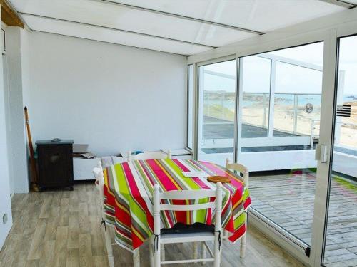 a dining room with a colorful table and chairs at Appartement Trégastel: Vue mer, Parking privé, Petit chien admis. - FR-1-542-5 in Trégastel