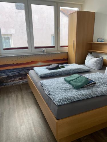 dwa łóżka w pokoju z dwoma oknami w obiekcie Haus Julianne, Wohnung Backbord, Familie Poppinga w mieście Norderney