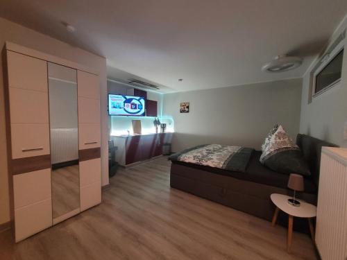 1 dormitorio con 1 cama y TV. en Ferienwohnung oder Studio Dresden-Neustadt inkl Parkplatz mit Balkon oder Terrasse en Dresden