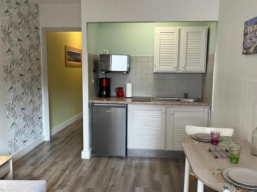a kitchen with white cabinets and a counter top at CARANCO by K6 Conciergerie in Cassis