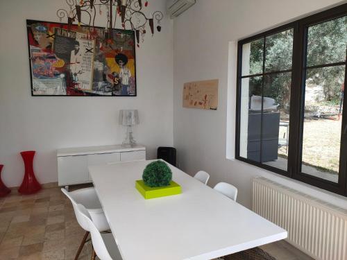 une salle à manger blanche avec une table et des chaises blanches dans l'établissement Bastide vue exceptionnelle, à Aix-en-Provence