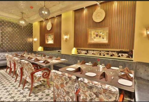 een eetkamer met lange tafels en stoelen bij HOTEL Tu CASA DELHI AIRPORT in New Delhi