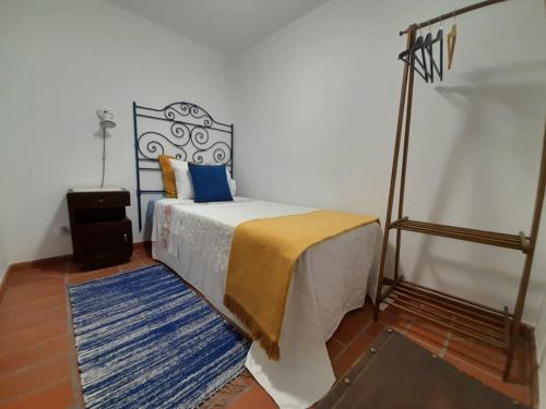 1 dormitorio con 1 cama con manta azul y amarilla en Casa do Avô Lopes, en Tomar