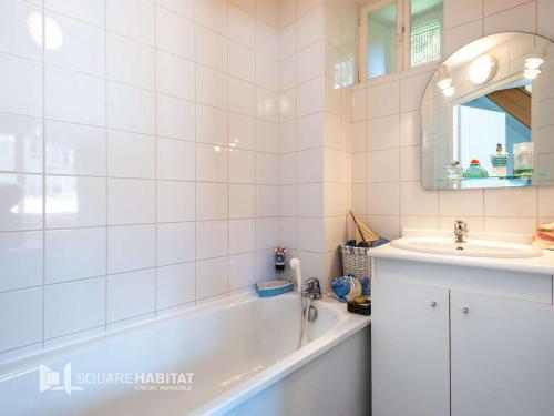 a bathroom with a bath tub and a sink at Villa Wimereux, 3 pièces, 4 personnes - FR-1-675-30 in Wimereux