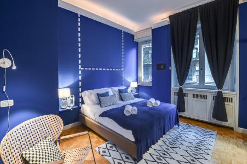 een blauwe slaapkamer met een bed en een stoel bij Sweet Inn - Cerva in Milaan