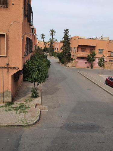 an empty street next to a brick building at Marrakech in Marrakech